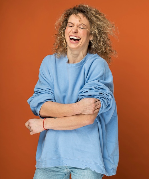 Giovane donna con i capelli biondi ricci sorridente