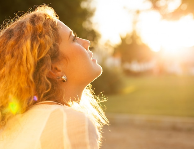 Young woman with curly hair enjoying a sunny day