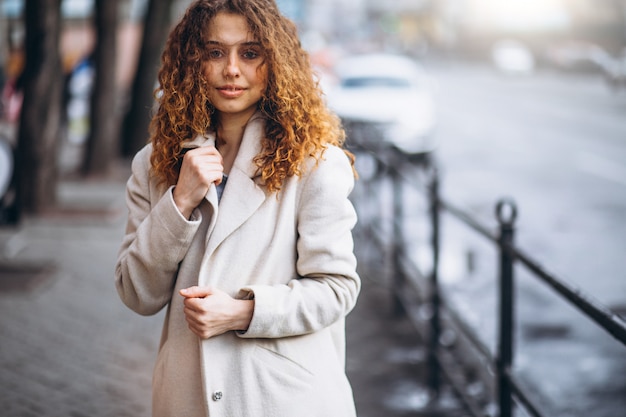 Young woman with curly hair outside the street