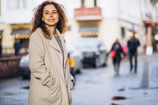 通りの外の巻き毛を持つ若い女性