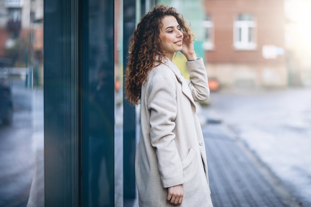 Young woman with curly hair outside the street