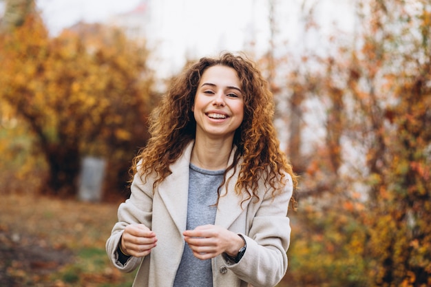 Giovane donna con i capelli ricci nel parco