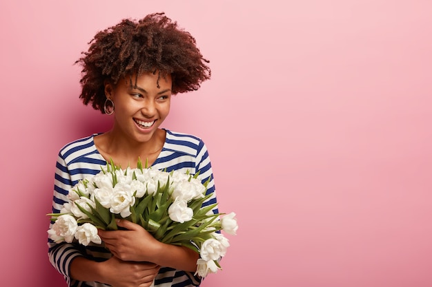 Free photo young woman with curly hair receiving bouquet of white flowers