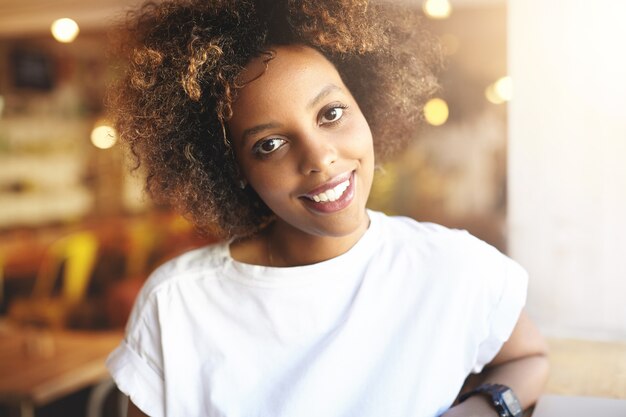 Young woman with curly hair sitting in cafe