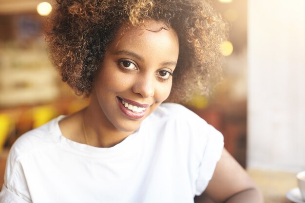 Young woman with curly hair sitting in cafe