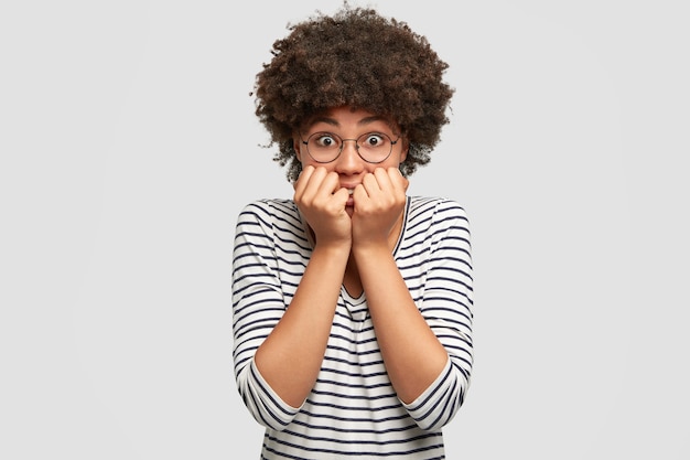 Foto gratuita giovane donna con i capelli ricci che indossa camicetta a righe