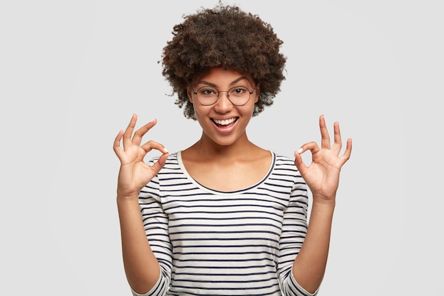 Free photo young woman with curly hair wearing striped blouse