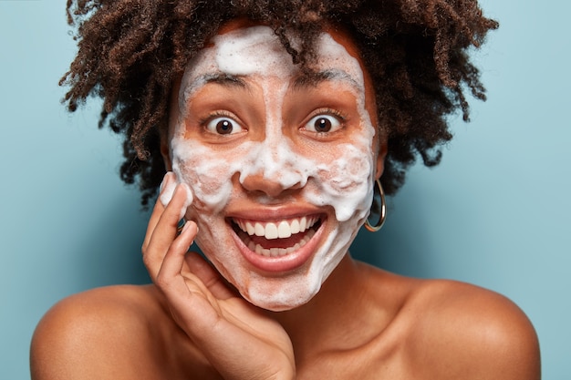 Free photo young woman with curly hair with face mask