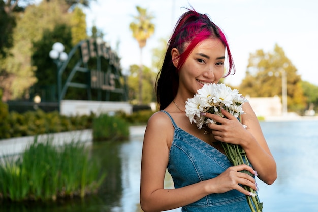 Free photo young woman with dyed hair near lake