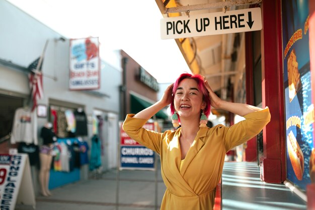 Young woman with dyed hair near shop