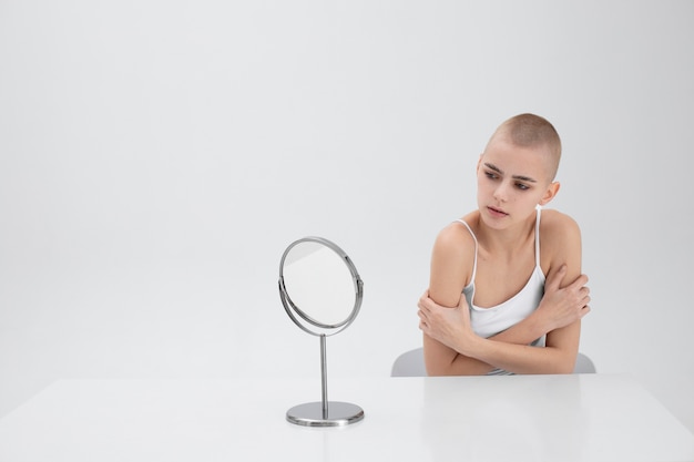 거울로 자신을 확인하는 섭식장애를 가진 젊은 여성