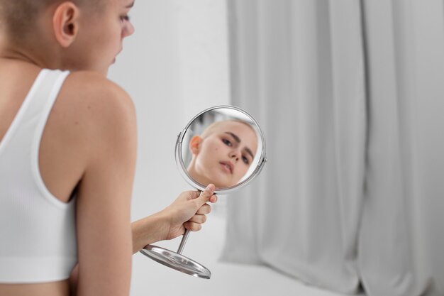 Free photo young woman with an eating disorder checking herself in the mirror