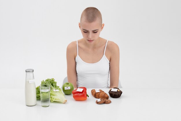 Young woman with an eating disorder next to food with calories numbers