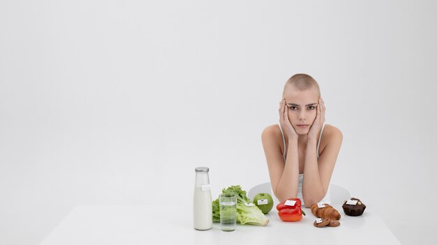 Young woman with an eating disorder next to food with calories numbers