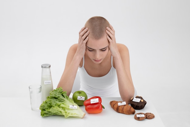 Young woman with an eating disorder next to food with calories numbers