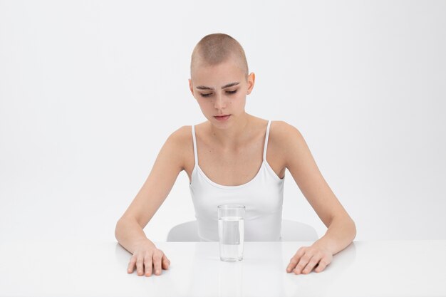 Young woman with an eating disorder looking at a glass of water