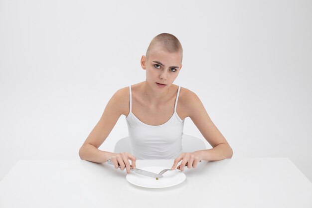 Young woman with an eating disorder wanting to eat a pea