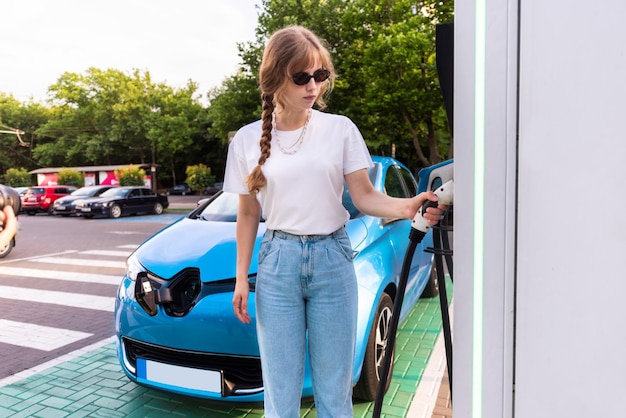 キシナウ モルドバの充電ステーションで電気自動車を持つ若い女性