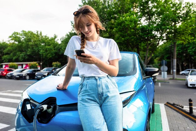Young woman with an electric car at charging station in Chisinau Moldova