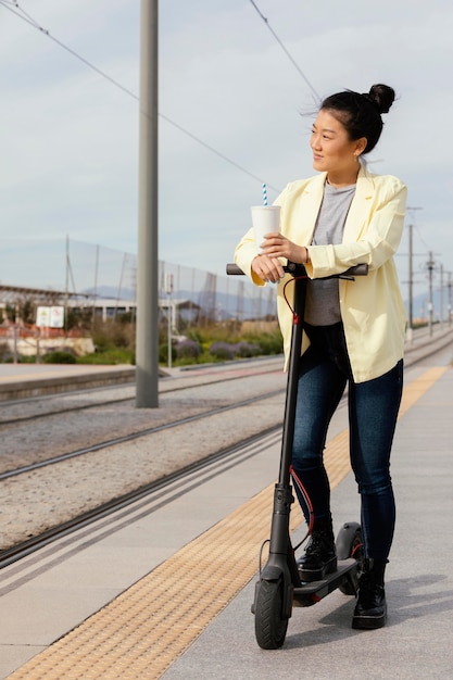 電動スクーターを持つ若い女性