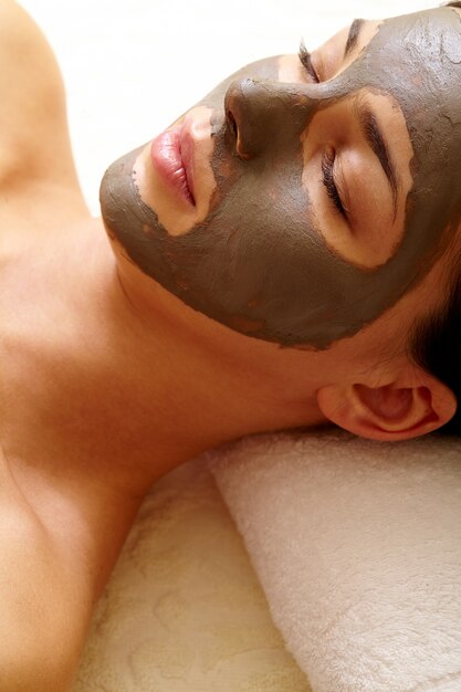 Young woman with facial clay mask