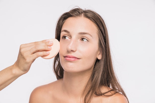 Young woman with facial sponge 