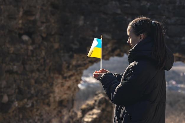 Una giovane donna con la bandiera dell'ucraina in mano