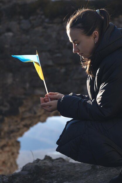 A young woman with the flag of ukraine in her hands