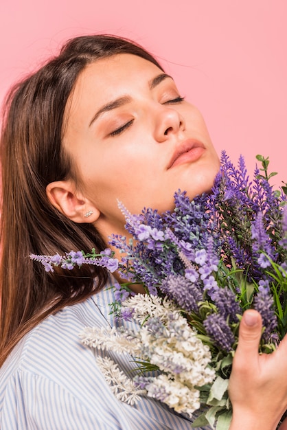 花の花束を持つ若い女