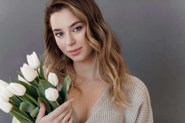 Free photo young woman with flowers tulips