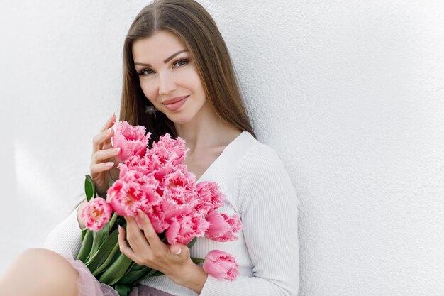 花のチューリップを持つ若い女性