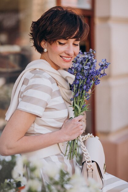 Young woman with flowers walking in town