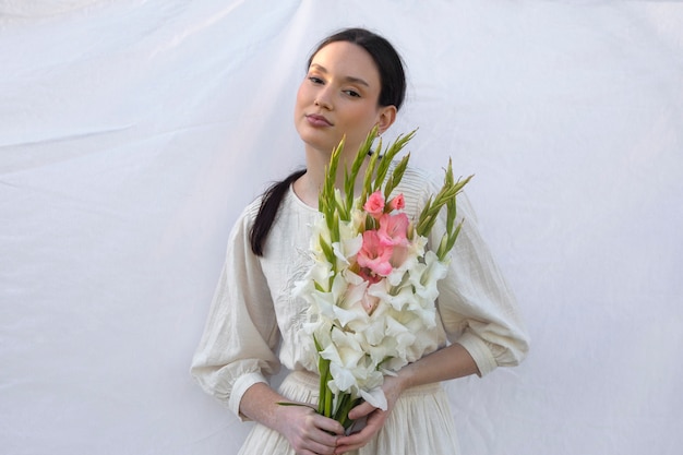 Free photo young woman with gladiolus in nature