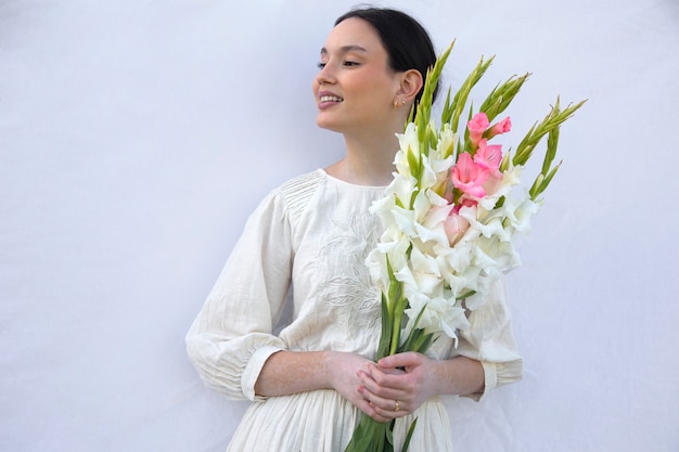 Foto gratuita giovane donna con gladiolo in natura