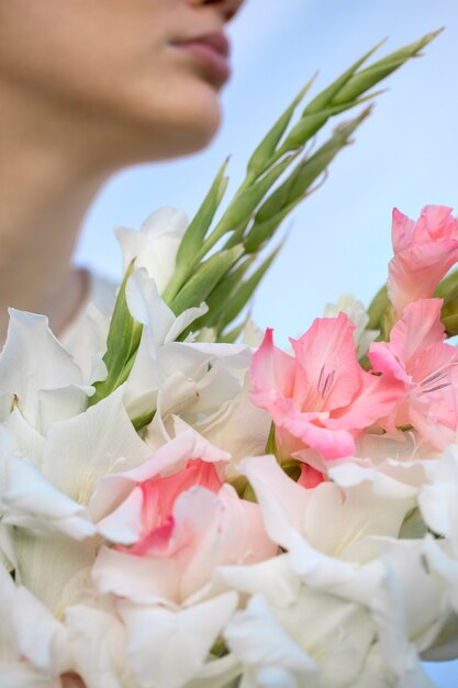 Young woman with gladiolus in nature