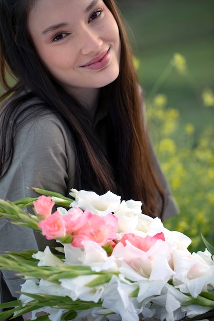 Free photo young woman with gladiolus in nature