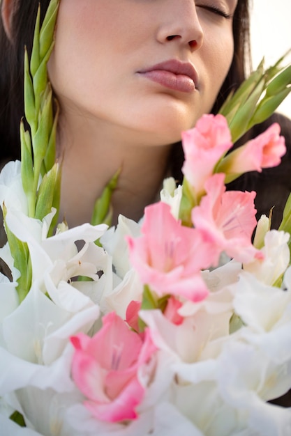 Young woman with gladiolus in nature