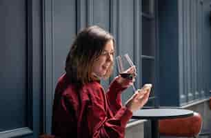 Free photo a young woman with a glass of wine on the terrace of a restaurant