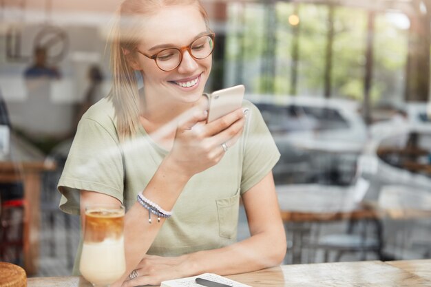 カフェで眼鏡を持つ若い女性