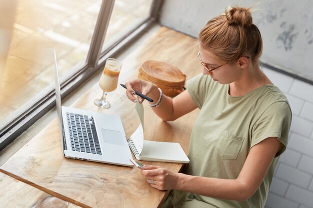 カフェで眼鏡を持つ若い女性