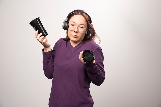 Young woman with glasses posing in headphones on a white background. High quality photo