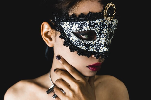 Young woman with a gray venetian mask