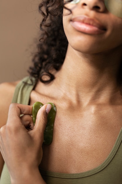 Young woman with gua sha low angle