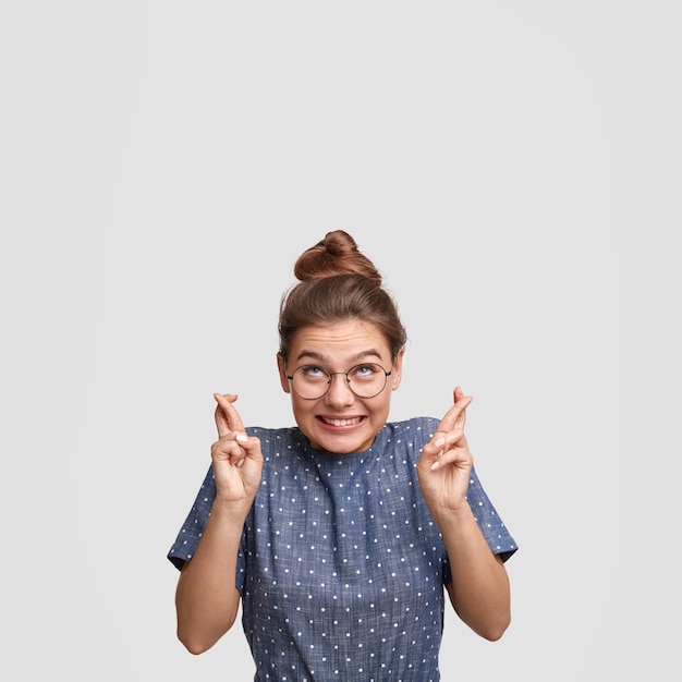 Young woman with hair in a bun wearing a dotted shirt