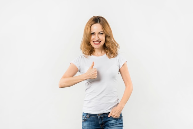 Young woman with hand in her pocket showing thumb up sign