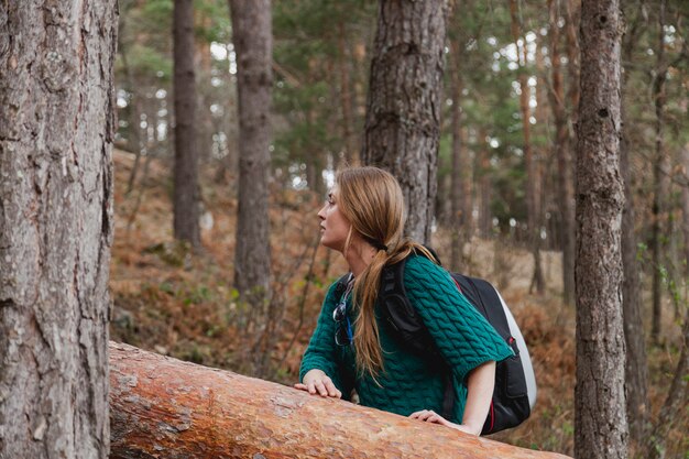 Young woman with hands on a log