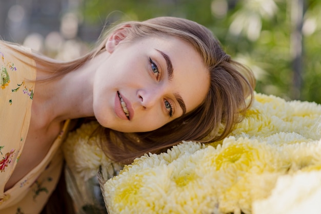 Young woman with head on flowers