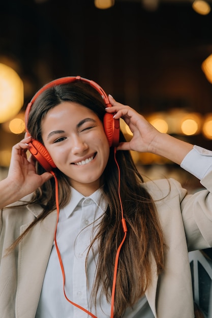 Young woman with headphones listen music while sitting in cafes