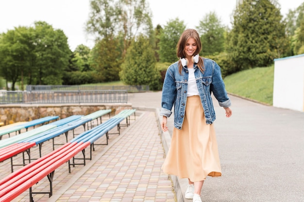 Young woman with headphones walking in park