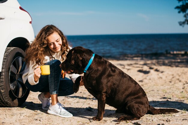 ビーチで彼女の犬を持つ若い女